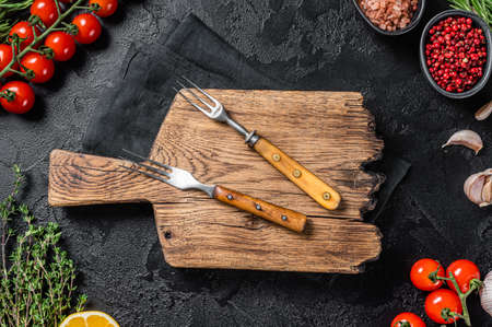 Ingredients for cooking and empty cutting board on old wooden table, Food cooking and healthy eating background. Black background. Top view. Copy spaceの写真素材