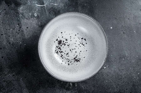 Food cooking background, empty white craft plate on table. Table setting. Black background. Top view. Copy spaceの写真素材