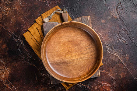Table setting with vintage empty wooden plate on rustic wood. Dark background. Top view. Copy spaceの写真素材