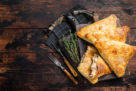 Baked samosa with chicken and cheese, samsa pies. Wooden background. Top view. Copy spaceの写真素材