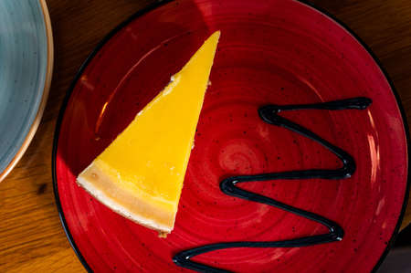 Classic New York strawberries and lemon Cheesecake on a wooden table in cafe. Top view