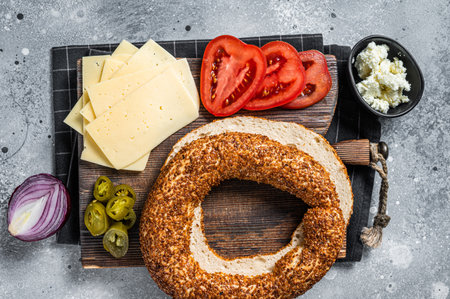 Cooking Bagels Sandwiches with cream cheese, ham, tomato and green rocket. Gray background. Top viewの写真素材
