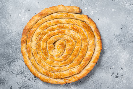 Baked homemade traditional Greek cheese pie on kitchen table. Gray background. Top viewの写真素材