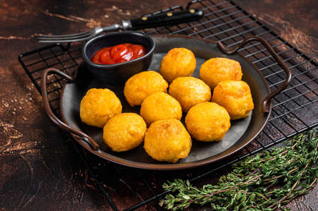 Potato croquettes, mashed potatoes balls breaded and deep fried. dark background. top view.