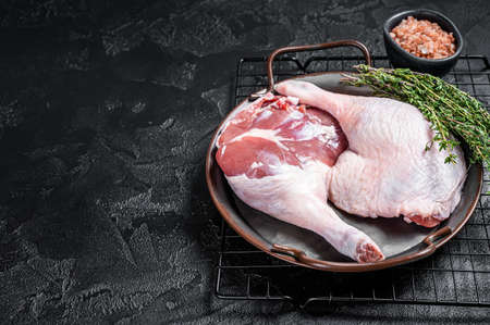 Raw Free range duck legs in a steel tray with thyme. Black background. top view. copyspace.の写真素材