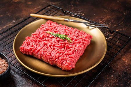 Fresh Raw mince beef, ground meat in a steel plate. dark background. top view.