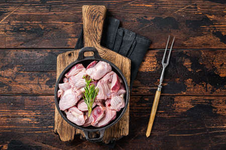 Raw chicken giblets gizzards, stomachs in a skillet ready for cooking. wooden background. top view.