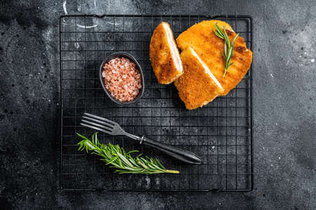 Schnitzel Cordon bleu fillet cutlet with ham and cheese. Black background. top view.