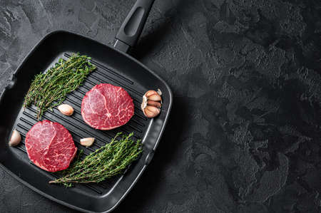 Tenderloin Raw Fillet Mignon beef steaks on a pan. Black background. top view. copyspace.の写真素材