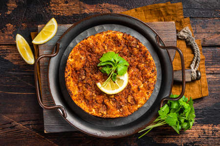 Traditional delicious Turkish foods lahmacun with mince lamb meat in steel tray. wooden background. top view.の写真素材