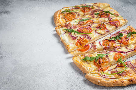 French tarte flambee with cream cheese, bacon, tomato and onions. Flammkuchen from Alsace region. white background. top view. copyspace.の写真素材