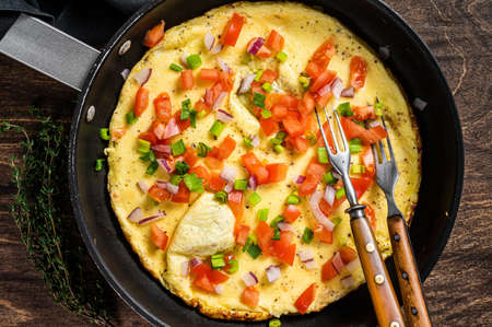 Healthy breakfast food, Stuffed egg omelet with vegetables in a skeleton. wooden background. top...