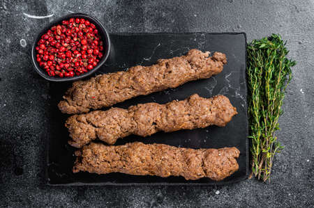 Grilled Shish kebab on a stick, from ground beef and lamb meat, turkish adana kebab. Black...