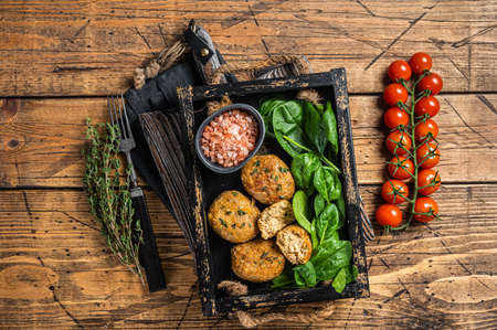 Seafood Fish balls or Fish cake with spinach and herbs in a tray. wooden background. top view.