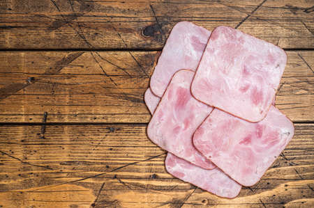 Square Slices of pork ham on wooden table. Wooden background. Top view. Copy spaceの写真素材