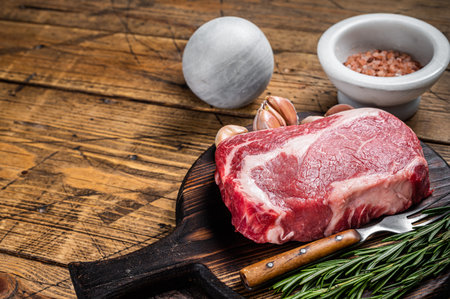 Raw Rib eye Steak, ribeye beef meat on wooden board with thyme. wooden background. top view. copyspace.の写真素材