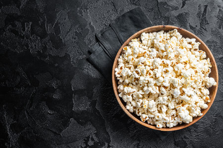 Salted popcorn in a wooden plate. white background. top view. copyspace.の写真素材