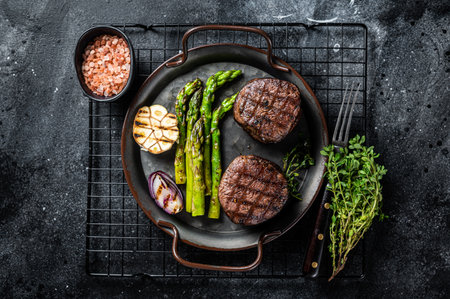 Grilled Fillet Mignon Steak with roasted asparagus. Black background. top view.の写真素材