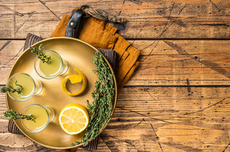 Limoncello shots, Italian lemon liqueur. wooden background. top view. copyspace.の写真素材