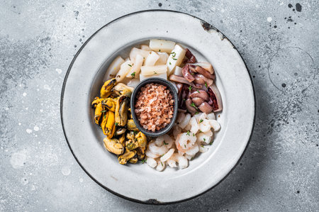 Raw seafood mix in a rustic plate. gray background. top view.