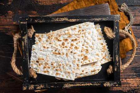 Passover matzos of celebration with matzo unleavened bread in a wooden tray with herbs. wooden...