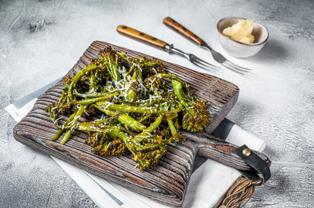 Baked Broccolini cabbage Sprouts with parmesan cheese on wooden board. white background. top view.の写真素材