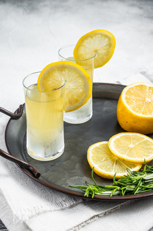 Traditional italian limoncello liqueur, lemon alcohol Digestive with lemon and rosemary. white background. top view.の写真素材