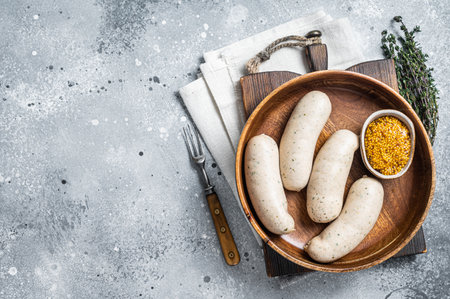 Bavarian white sausage in wooden plate with mustard. gray background. top view. copyspace.の写真素材