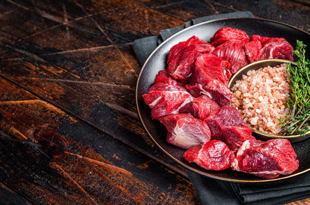 Raw lean diced casserole beef meat for cooking Goulash. wooden background.の写真素材