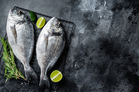 Raw sea bream dorado fish ready for cooking. Black background. top view. copyspace.の写真素材