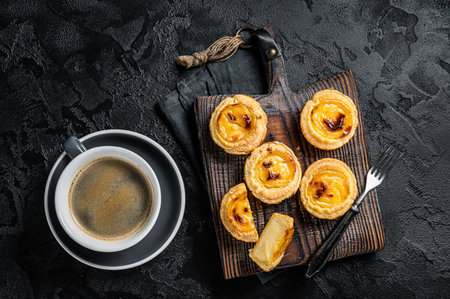 Custard Tarts Pasteis de Belem, Portuguese pastel de Nata. Black background. Top view