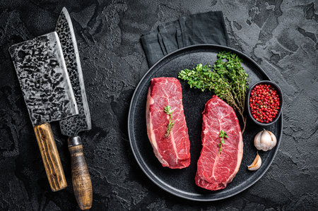 Dry aged Raw top blade flat Iron beef meat steaks. Black background. Top Viewの写真素材