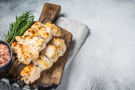 Chicken kebab skewers with onion and spices on wooden board. white background. top view. copyspace.の写真素材