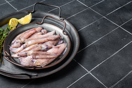 Raw squid with spices and lemon, fresh Seafood. Black background. top view. copyspace.