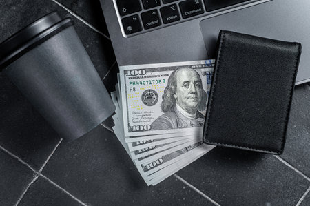 Corporate business desktop with laptop, digital tablet, wallet, money and cup of coffee. Black background. top view. copyspace.の写真素材