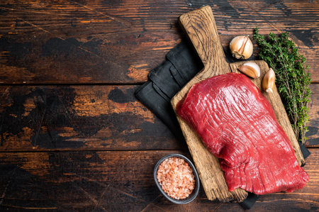 Alternative flank beef steak, raw meat. wooden background. top view. copyspace.の写真素材