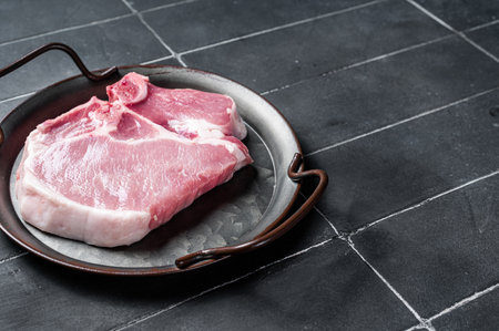 Raw pork t bone chop meat steak. Black background. top view. copyspace.の写真素材