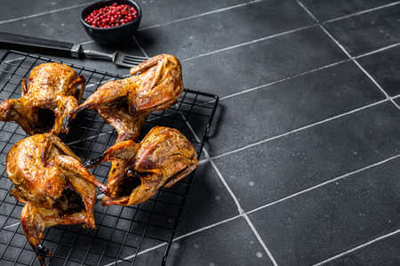 Grilled whole quails with herbs and spices. Black background. top view. copyspace.の写真素材