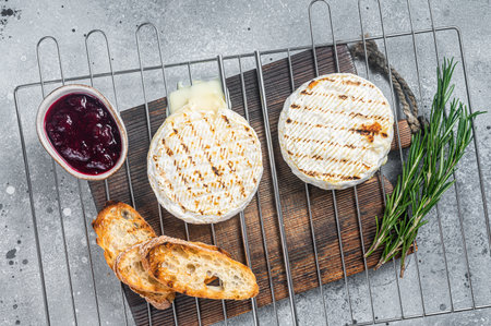 Grilled Camembert cheese on grill with cranberry sauce and toast. gray background. top view.の写真素材