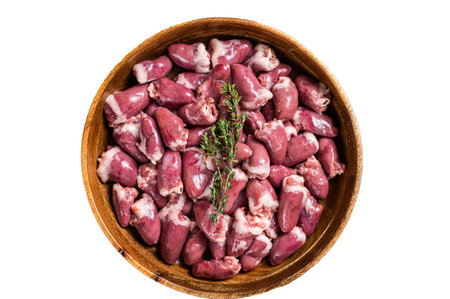 Raw chicken hearts in a wooden plate with herbs. organic offals. isolated on white background