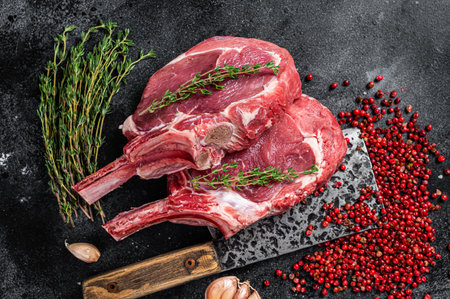 Raw Tomahawk rib veal steaks on butcher meat cleaver. Black background. top view.の写真素材