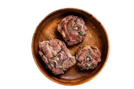 Fried lamb neck meat steaks in a wooden plate with herbs. isolated on white backgroundの写真素材