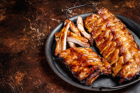 BBQ pork spare ribs St Louis with hot honey marinade in a steel tray. Dark background. Top view. Copy spaceの写真素材