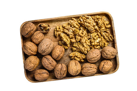 Walnuts in a wooden plate and walnut kernels. isolated on white background