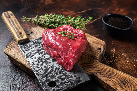 Raw rump steak on a butcher cutting board. dark background. top view.の写真素材