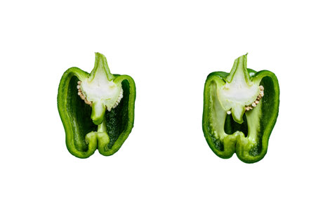 Cut green bell pepper, two halves. Black background. top view. Space for text sweet pepper, two...