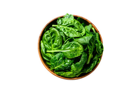 Young raw spinach in a wooden bowl. isolated on white background