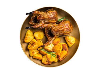 Delicious roasted quails with herbs in a plate with fried potato. isolated on white backgroundの写真素材