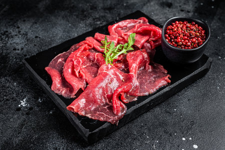 Slices of Beef Capriccio, raw marbled meat. Black background. Top view.の写真素材