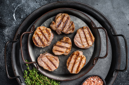 Roasted pork medallions steaks, tenderloin meat. Black background. Top view.の写真素材